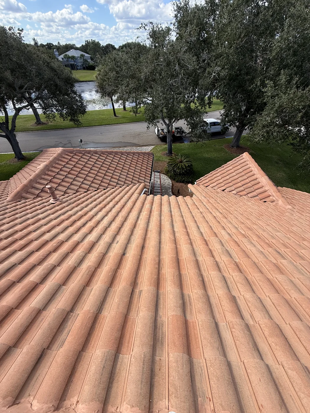 Completed Suntree barrel tile roof soft wash showing cleaned roof slopes and surrounding landscaping